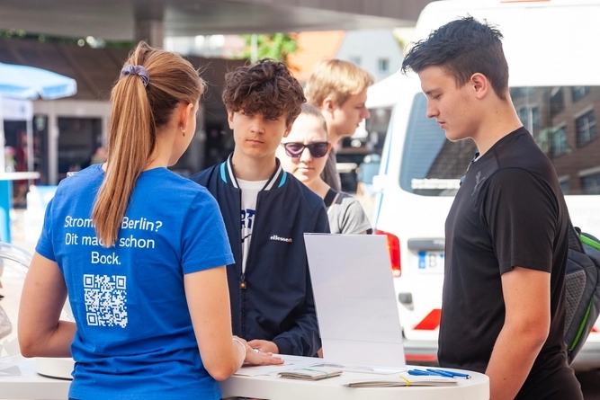 Zwei junge Menschen informieren sich über Ausbildungsangebote bei Stromnetz Berlin.