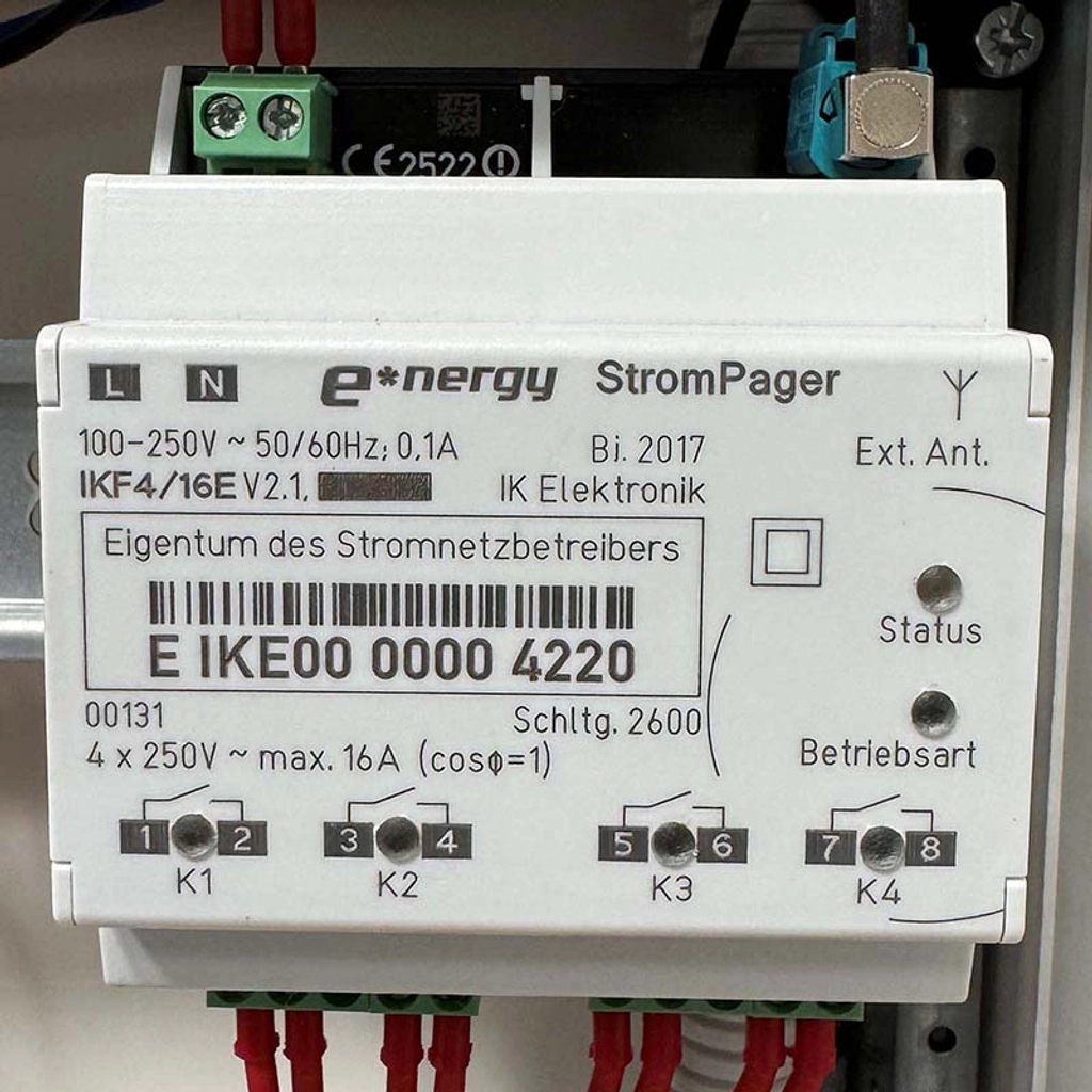Weißes StromPager Gerät mit ID, K1-K4 Anschlüssen, Barcode, LEDs and Kabeln