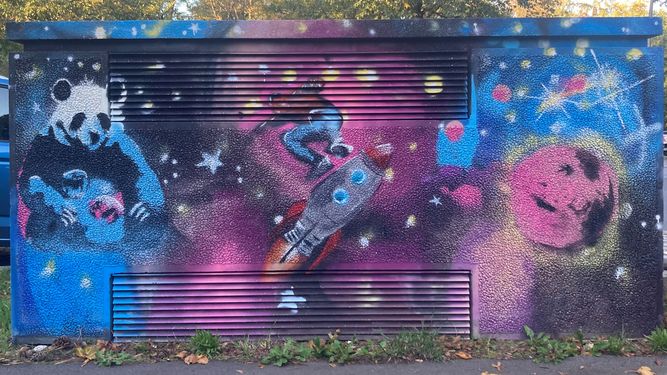 Ein Stromkasten, auf dem eine Erde vor dem Hintergrund einer Sternengalaxie aufgemalt ist.